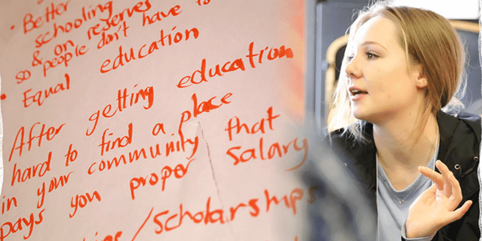 There are handwritten notes on a whiteboard or paper listing several educational issues and suggestions. Next to the notes, there is a person speaking or discussing something.